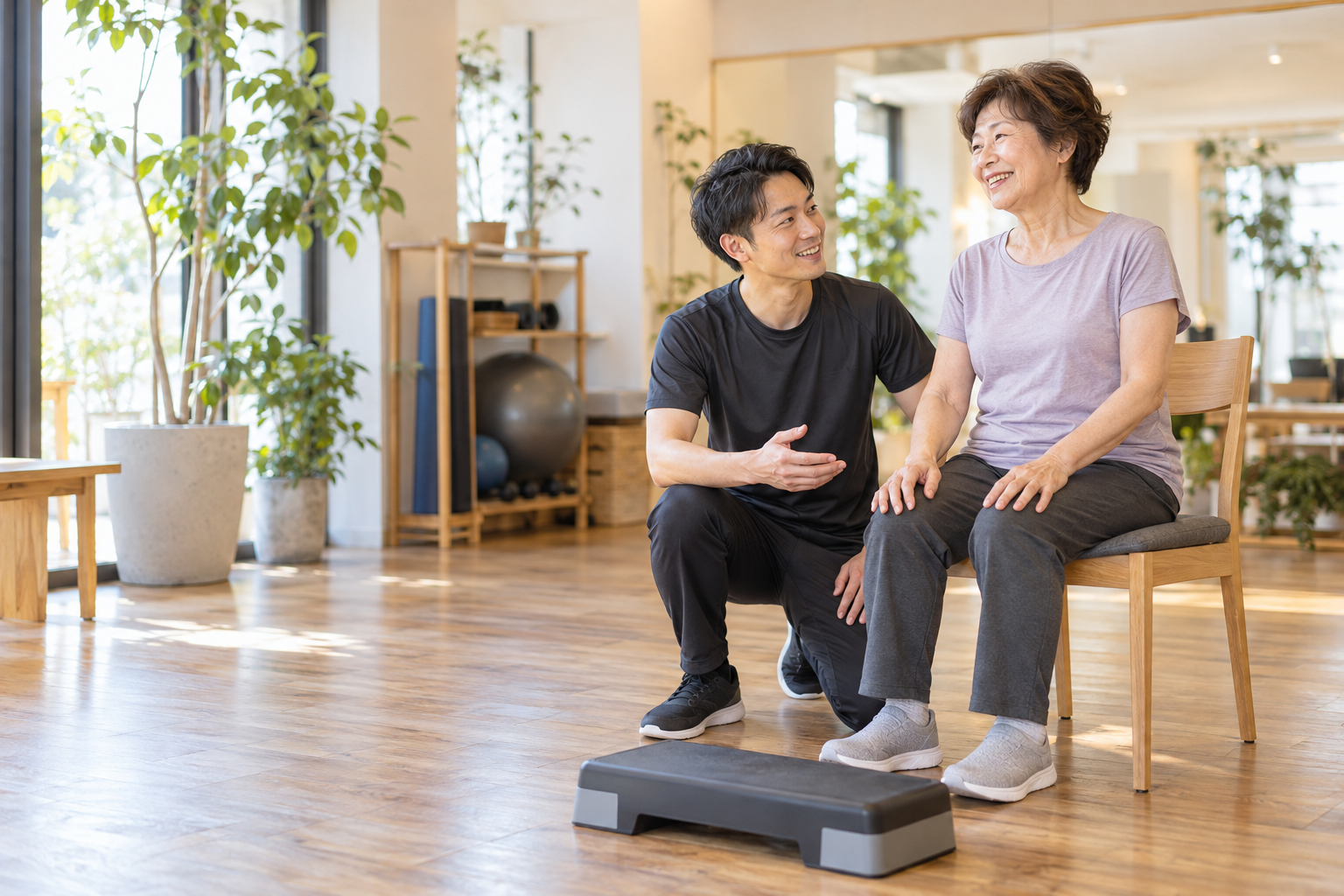 椅子から立つ運動をする女性とトレーナー